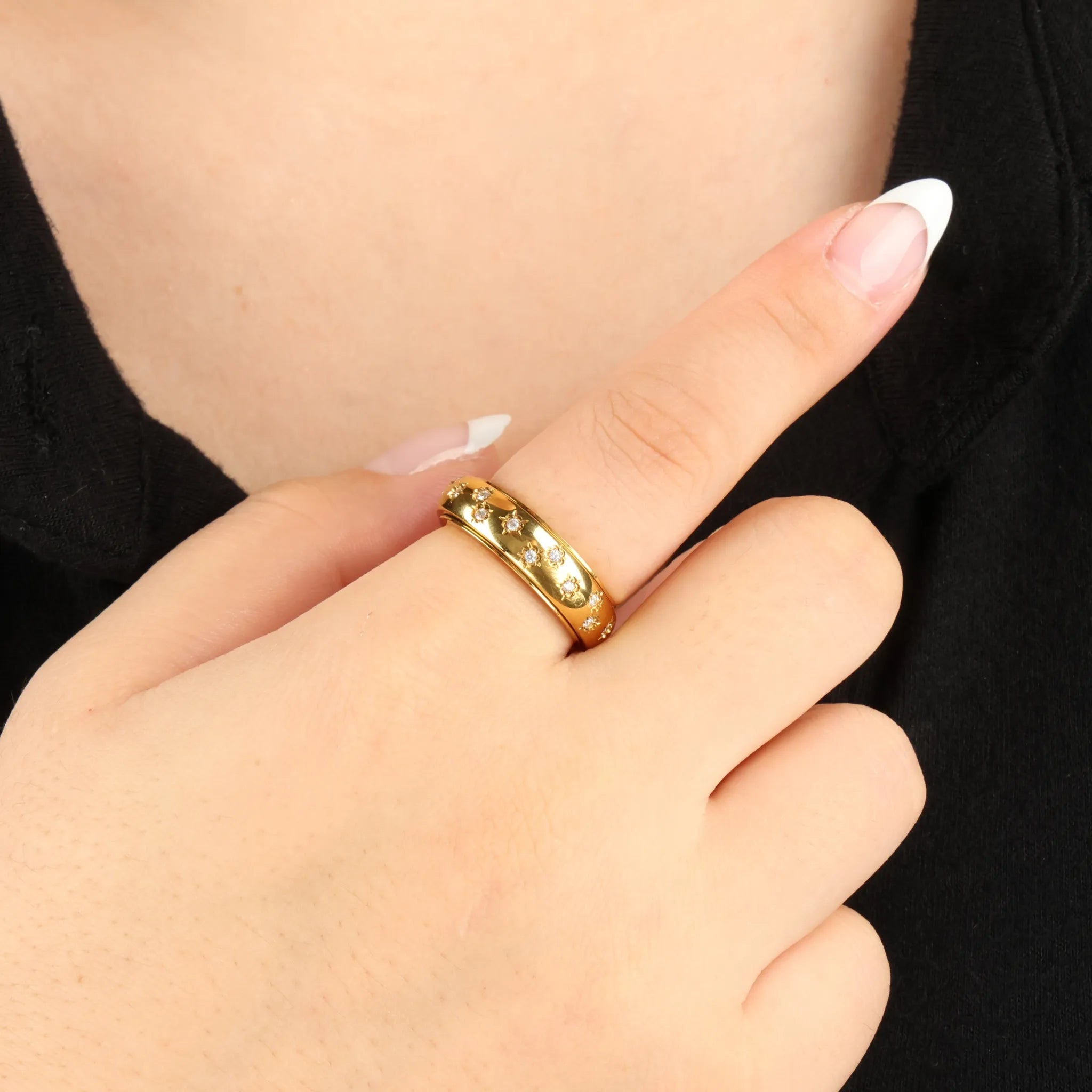 Close-up van gouden Allura Fidget Ring met bloemgravure en steentjes – Luminora