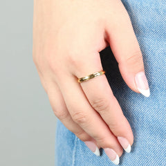 Gouden Amara stress ring met subtiel golvend patroon gedragen bij spijkerbroek – Luminora