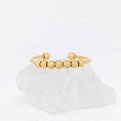 Gouden Bead anxiety ring van stainless steel met glanzende kralen, vastgelegd in studioverlichting – Luminora