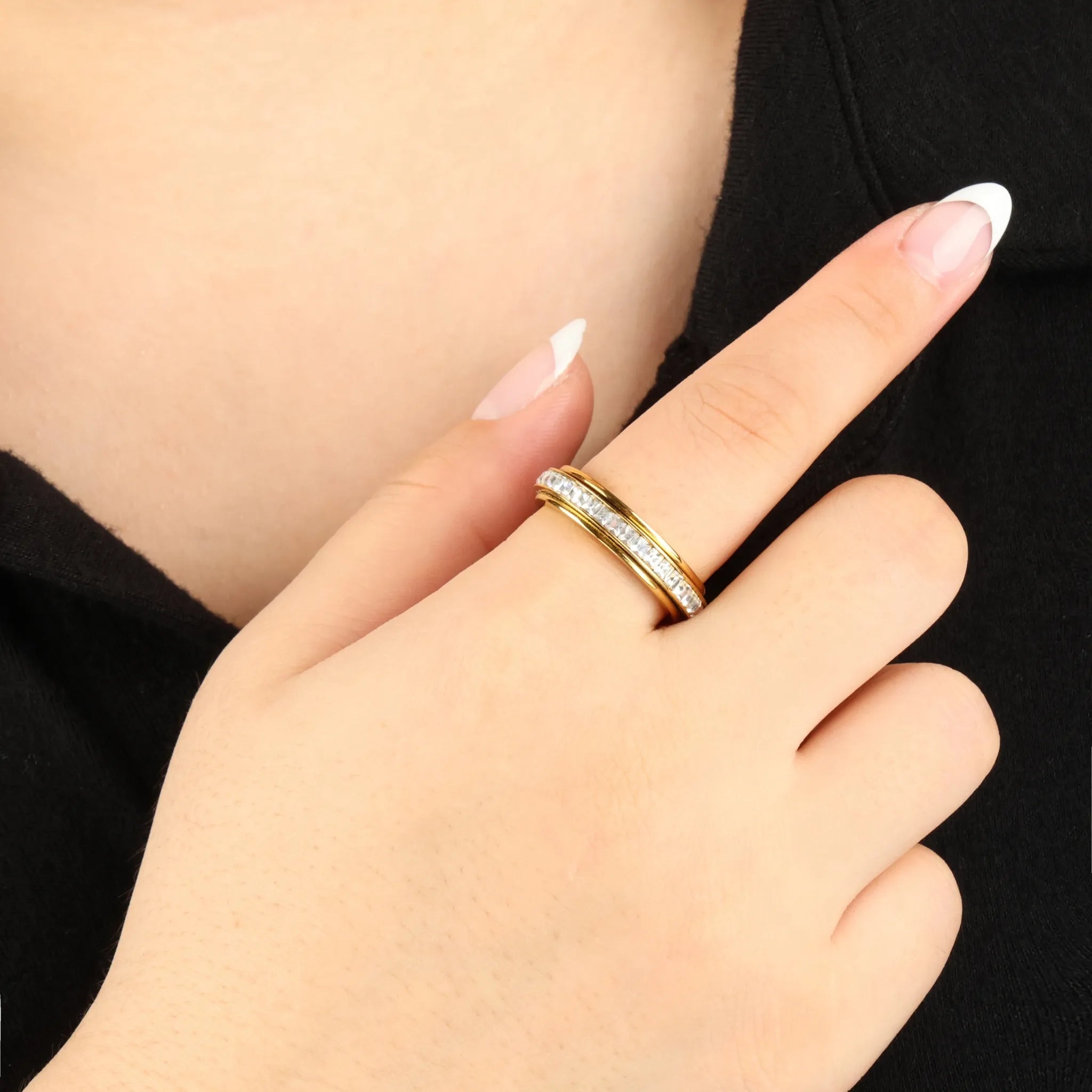Gouden Elevate anxiety ring met heldere kristallen gedragen bij zwarte outfit – Luminora
