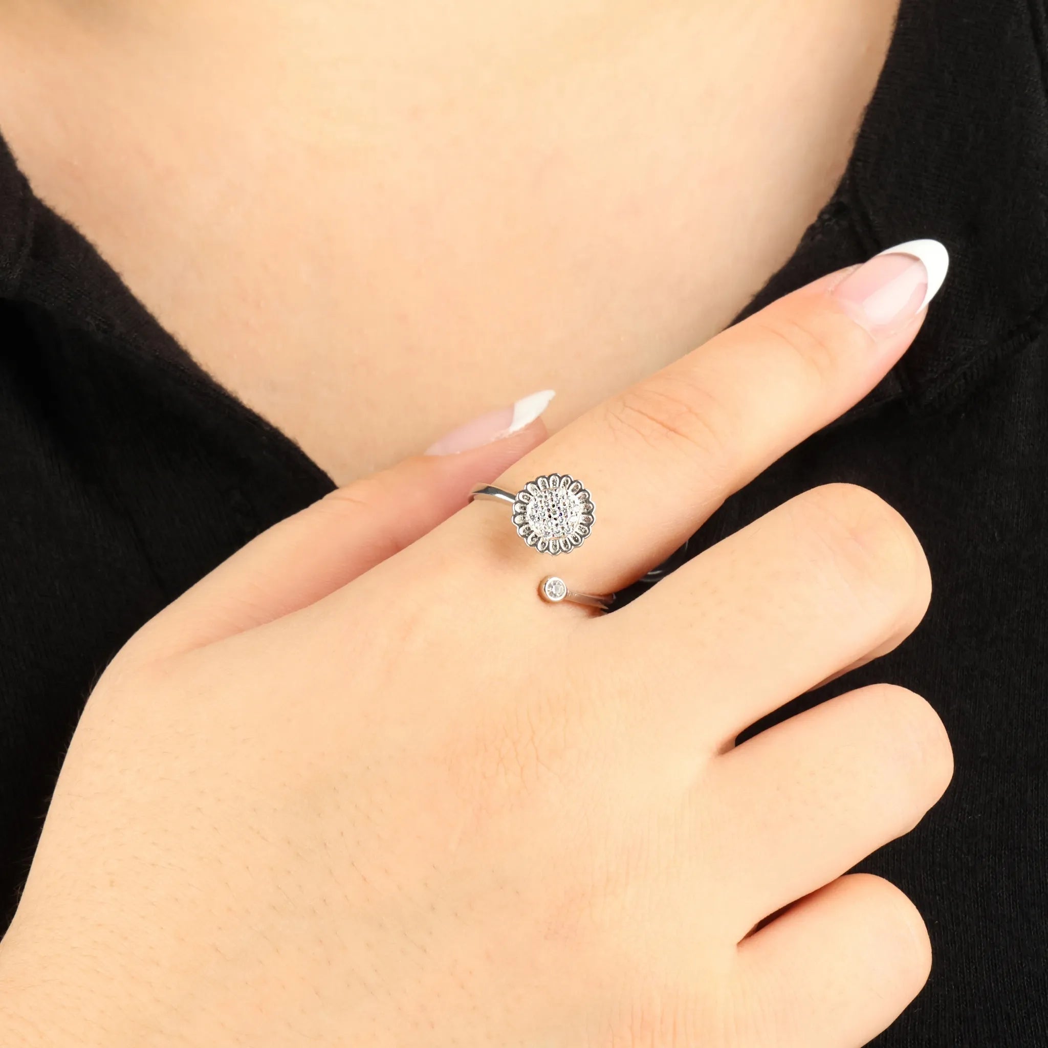 Silver plated Lotus anxiety ring gedragen bij zwarte blouse, verstelbaar ontwerp met bloem en kristal – Luminora