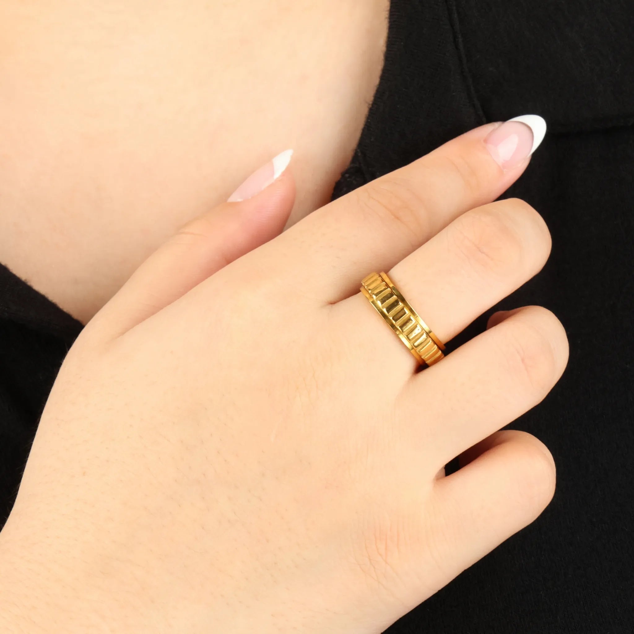 Gouden Arden fidget ring met ribstructuur gedragen voor zwart shirt – Luminora