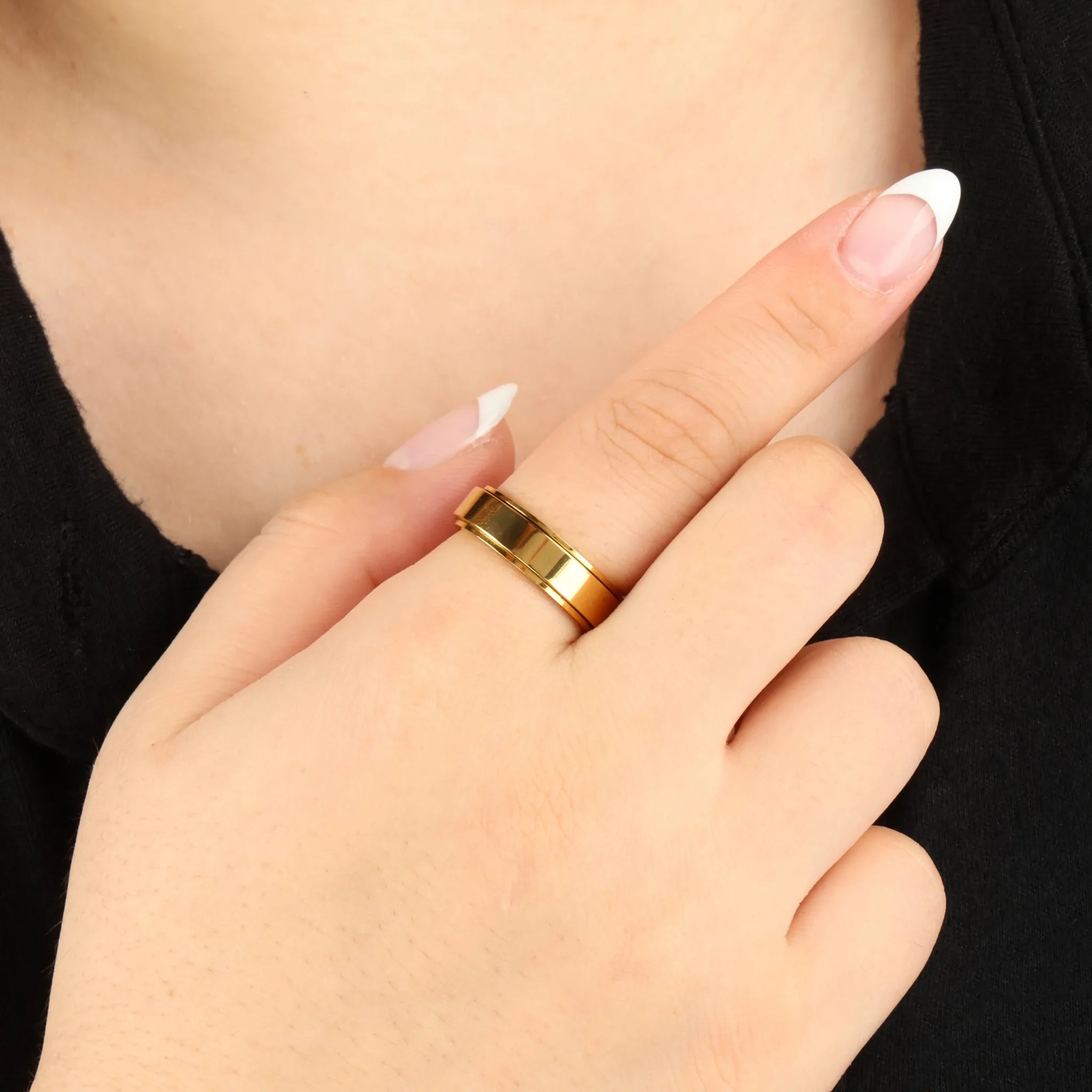 Gouden Aura fidget ring bij zwart shirt, strak en tijdloos