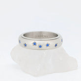Azura fidget ring van edelstaal met glanzende afwerking, bloemgravure en helderblauwe stenen – Luminora