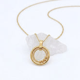 Bead Ketting in goud van RVS met beweegbare kralen op een witte steen – stijlvolle fidget ketting voor rust en ontspanning.