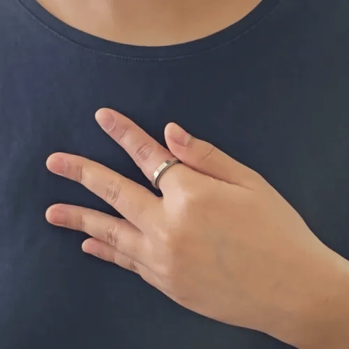 Bewegende animatie van de Fortuna fidget ring die laat zien hoe de band met het gegraveerde klavermotief soepel ronddraait.