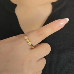 Bewegend beeld van de gouden Clover fidget ring om de vinger om de soepele rotatie en de stressverlichtende werking te demonstreren.