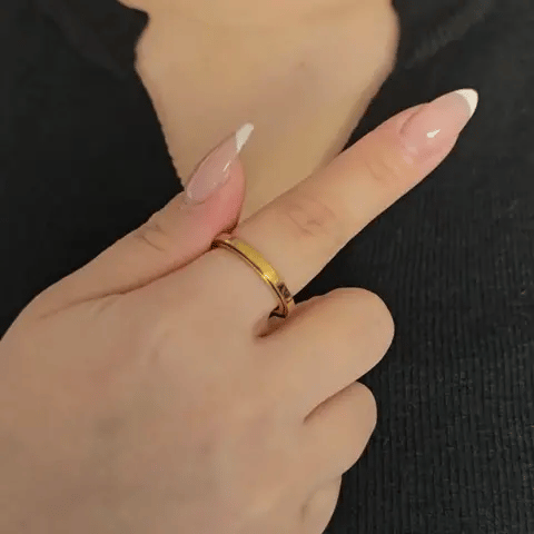 Draaiende gouden Marea fidget ring in actie, met focus op de soepele beweging van het elegante golfdesign.