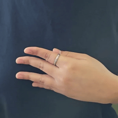Bewegende animatie van de Roa fidget ring die demonstreert hoe de band met het golfpatroon en de steentjes soepel ronddraait.