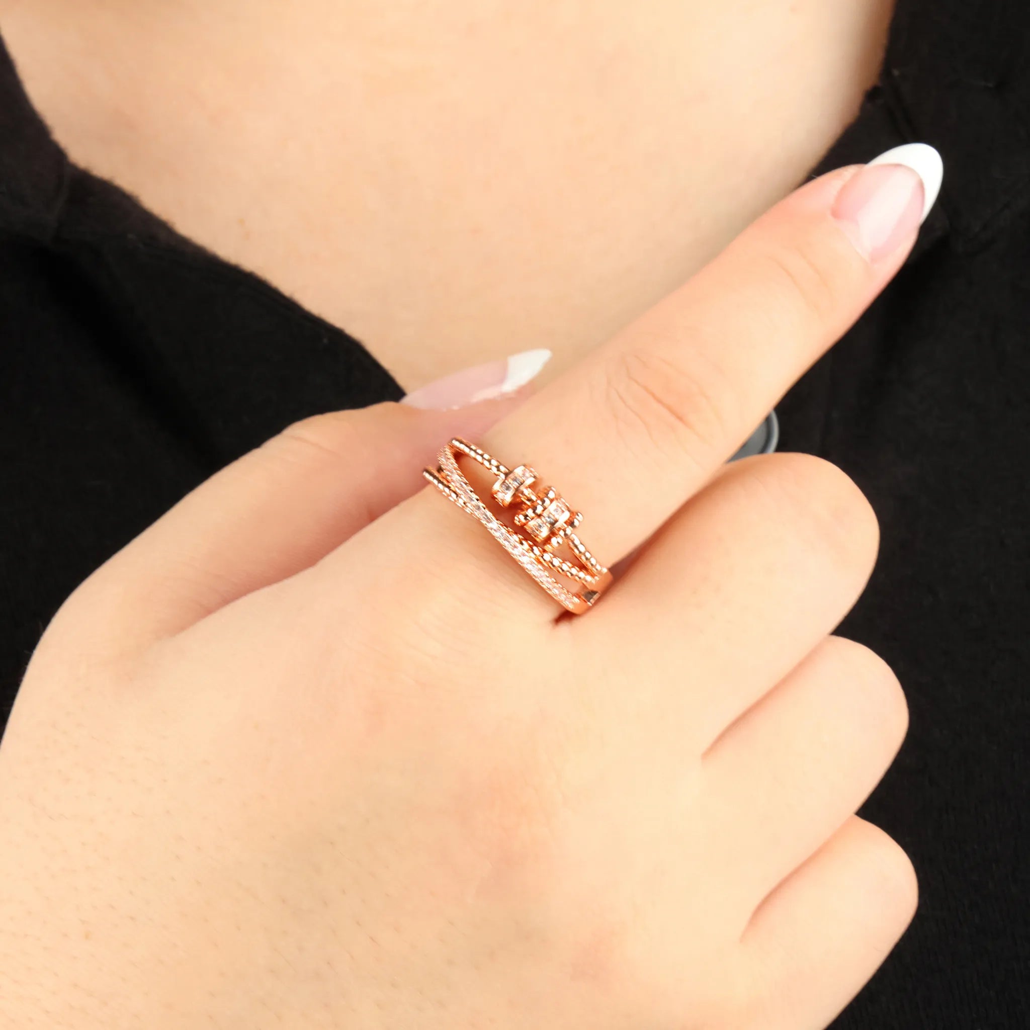 Close-up van hand met roségouden Serenity stress ring – elegante look en stressverlichting – Luminora