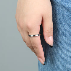 Vrouw draagt zilveren Essence anxiety ring, dun en stijlvol bij spijkerbroek – Luminora