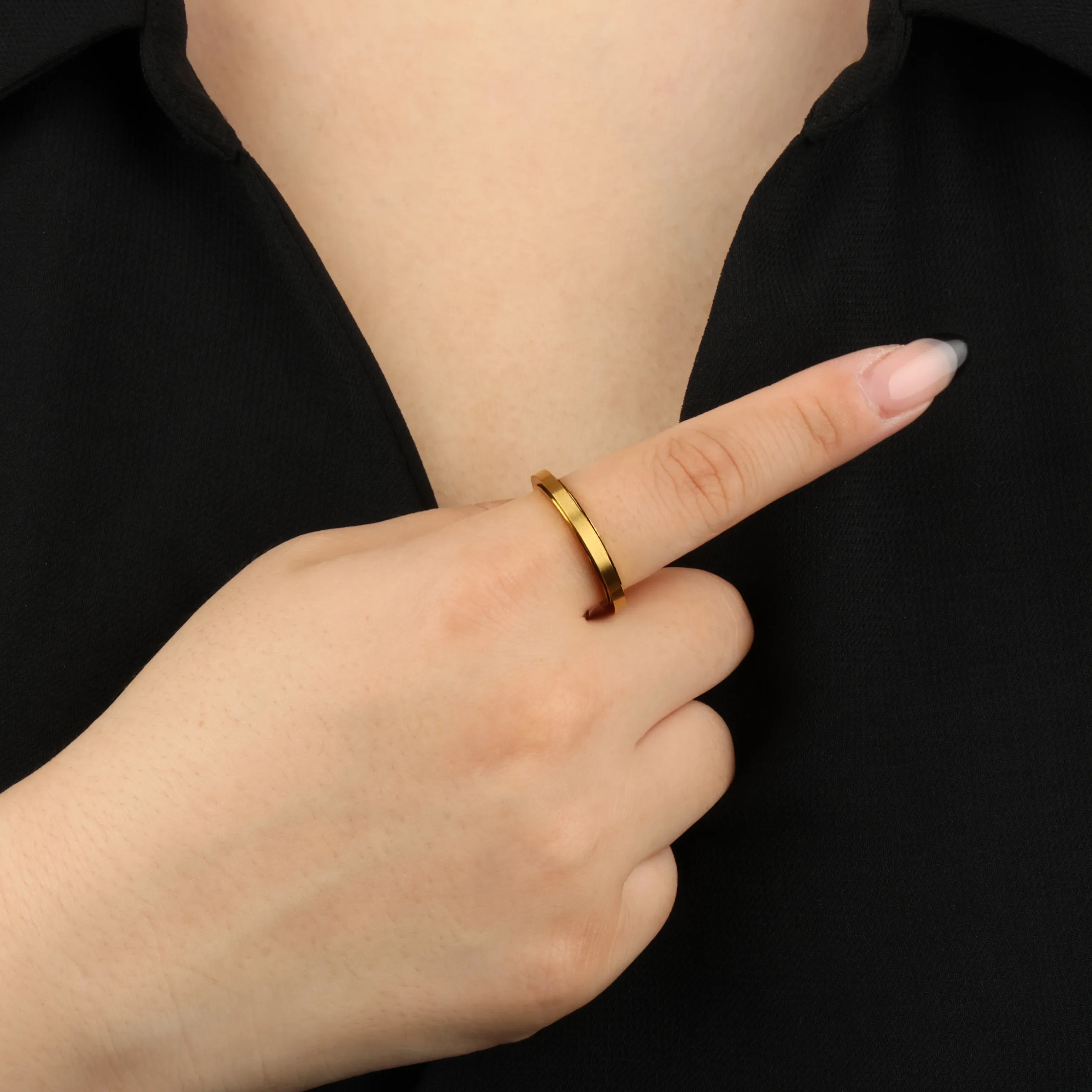 Gouden Essence fidget ring gedragen door vrouw met zwart shirt – Luminora