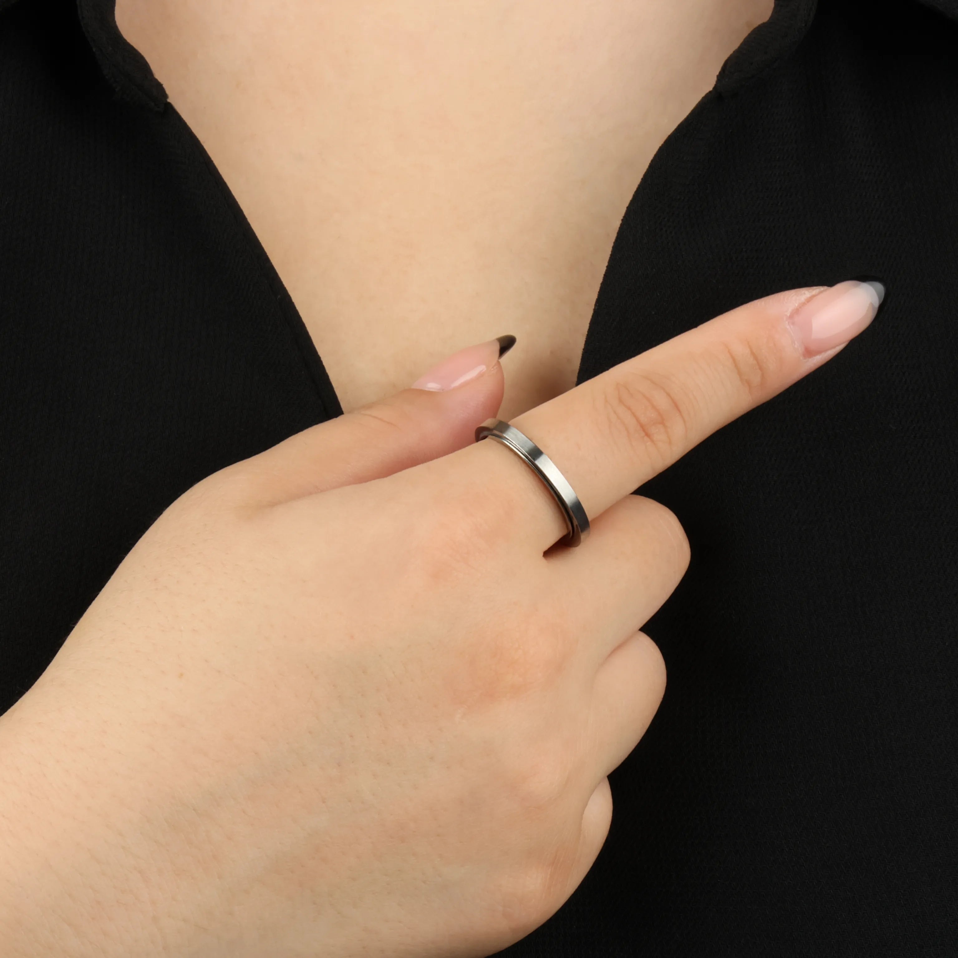 Zilveren Essence fidget ring gedragen door vrouw met zwart shirt – Luminora