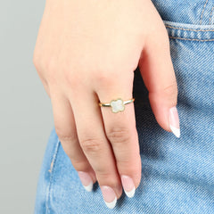 Gouden Clover fidget ring gedragen aan hand op denim jeans, elegant en stijlvol ontwerp