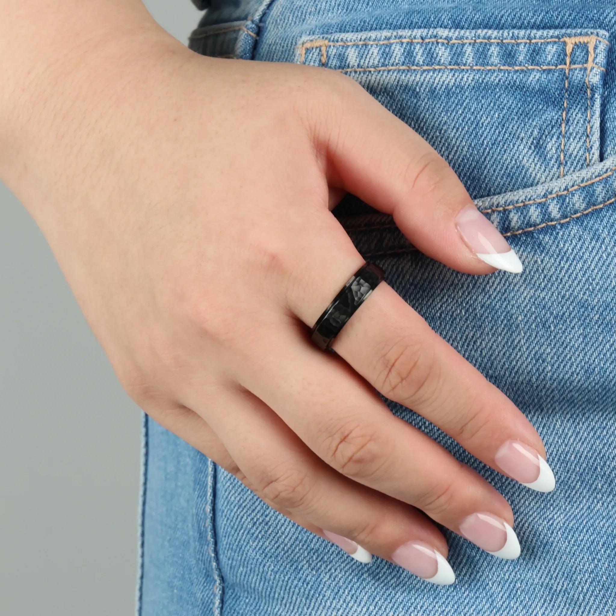 Zwarte Echo fidget ring gedragen aan hand op denim jeans, stoer en minimalistisch design