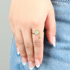 Gold plated Lotus fidget ring gedragen aan hand op jeans, verstelbaar bloemdesign met glanzend kristal