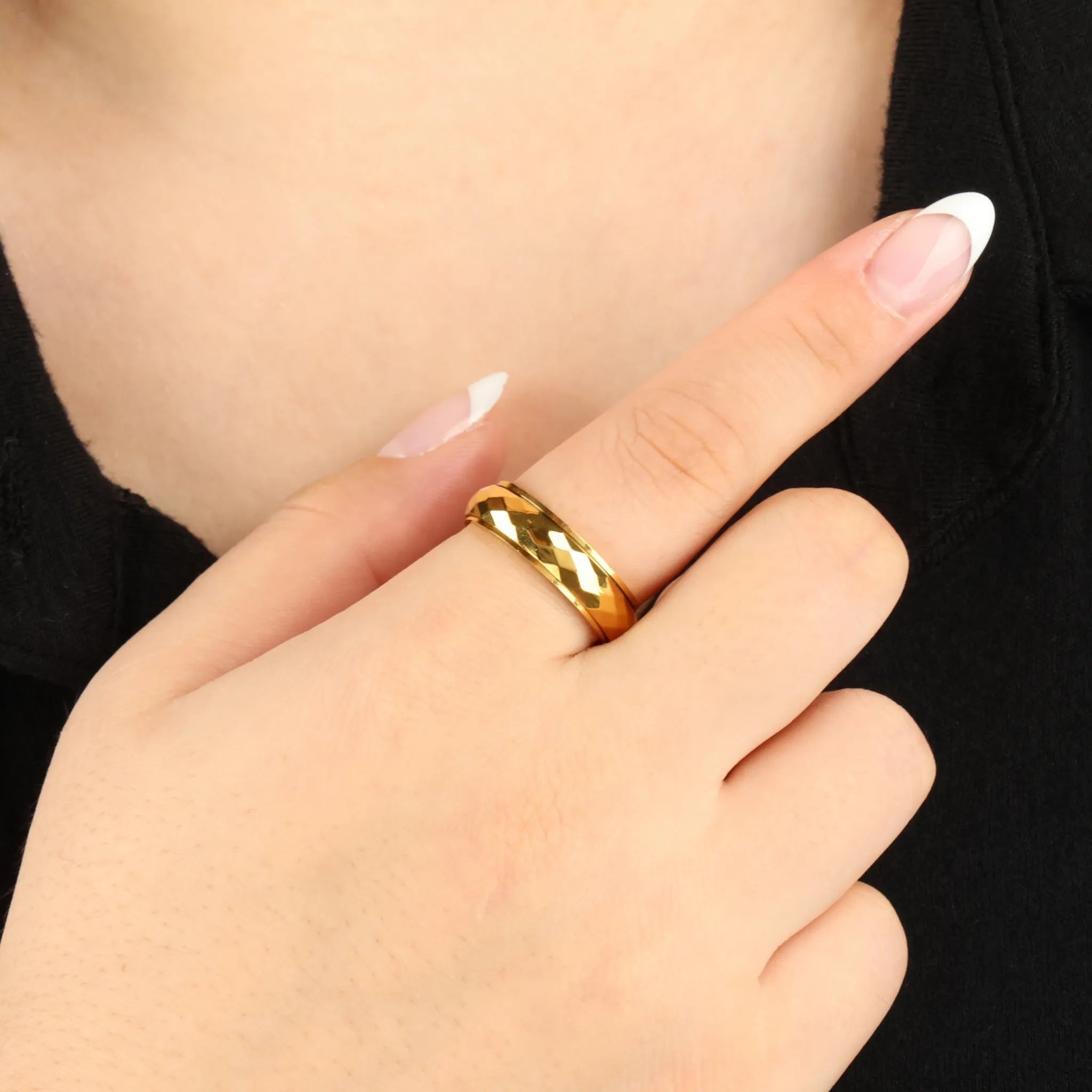 Gouden Nova fidget ring met hamerslag-detail, gedragen bij zwarte top – Luminora