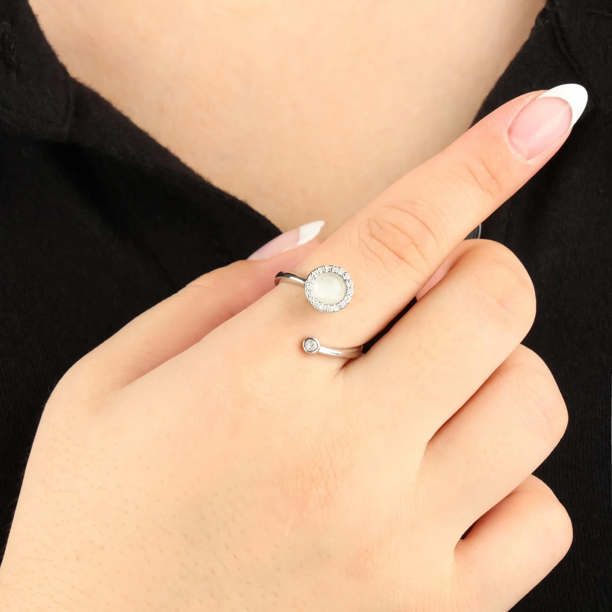 Zilveren Opal fidget ring met kristalaccenten rond een opaalsteen, gedragen bij zwarte outfit – rustgevend en verfijnd