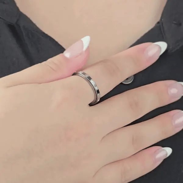 Animatie van de zilverkleurige Raya fidget ring van stainless steel met ingelegde kristallen – rustgevend ontwerp voor focus en ontspanning