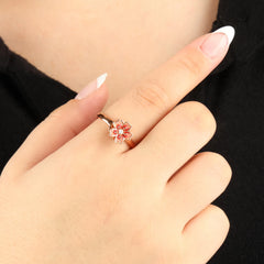 Roségouden Sakura fidget ring met bloemmotief en kristal, gedragen bij zwarte outfit – stijlvolle draairing voor ontspanning en focus