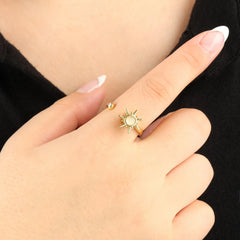 Gouden Solar fidget ring met glanzende steen en zonvorm, gedragen bij zwarte top – modieus sieraad met rustgevend effect