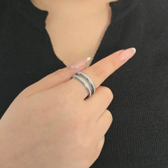 Elegante zilveren fidget ring met een dubbele rij fonkelende steentjes, gedragen door een model met een chique zwart topje.