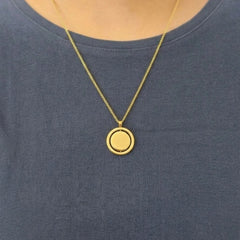 Model met een blauw shirt die de gouden Oracle anxiety ketting van RVS rond de hals draagt.