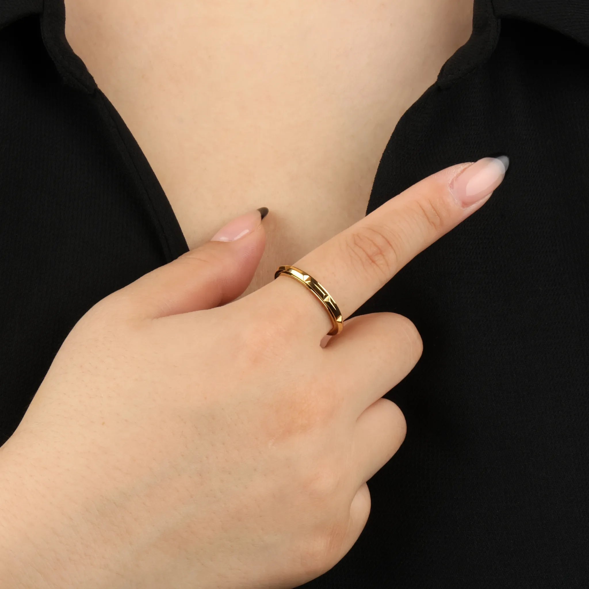 Gouden Hexa stress ring met zeshoekgravure op hand bij zwart shirt – Luminora