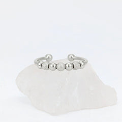 Zilveren Ivy Bead anxiety ring ontworpen met elegante kraaltjes, geplaatst op een witte kwartssteen.
