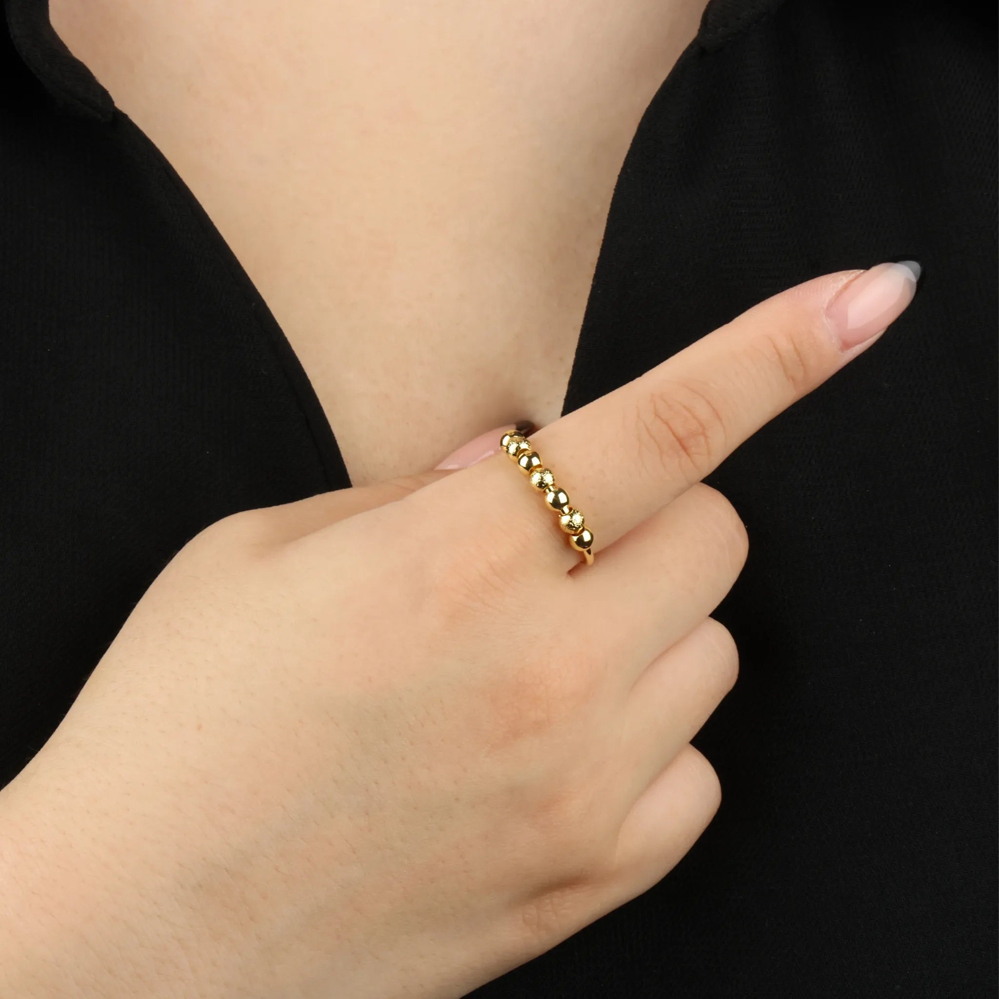 Gouden Ivy Bead fidget ring met geribbelde kralen gedragen bij zwart shirt – Luminora