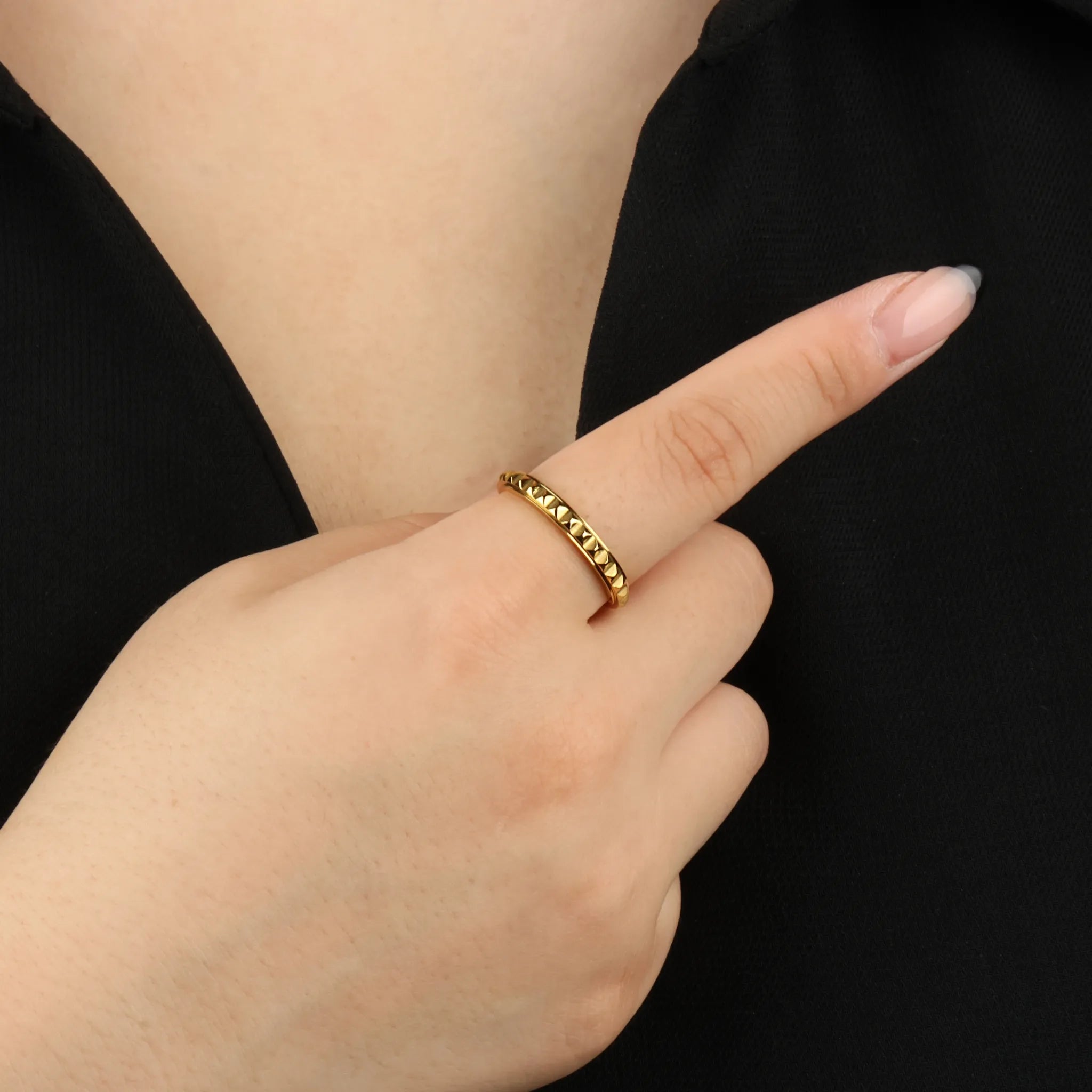 Vrouw draagt gouden Lumen stress ring met studpatroon voor rust – Luminora