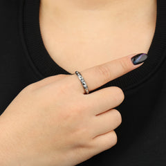 Zilveren Lumi anxiety ring gedragen aan vrouwenhand voor borst met zwart shirt – Luminora