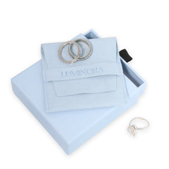 Luminora suède sieradenpouch op blauw cadeau-doosje met twee zilverkleurige ringen en een verstelbare bloemring ernaast – luxe verpakking voor fidget ringen