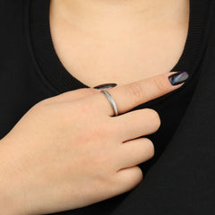 Zilveren Mello anxiety ring gedragen aan vrouwenhand voor borst met zwart shirt – Luminora