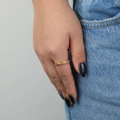 Gouden Mello fidget ring gedragen aan vrouwenhand met spijkerbroek – Luminora