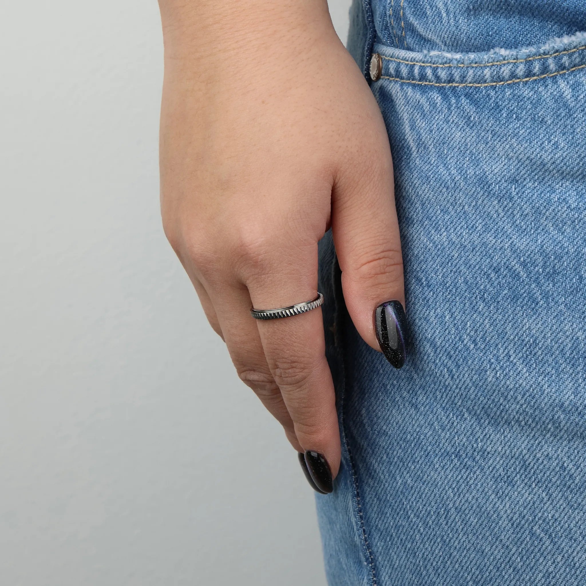 Zilveren Mello fidget ring gedragen aan vrouwenhand met spijkerbroek – Luminora
