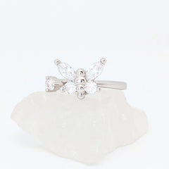 Zilveren Nabi fidget ring in de vorm van een vlinder met heldere zirkonia kristallen, gepresenteerd op een witte steen.