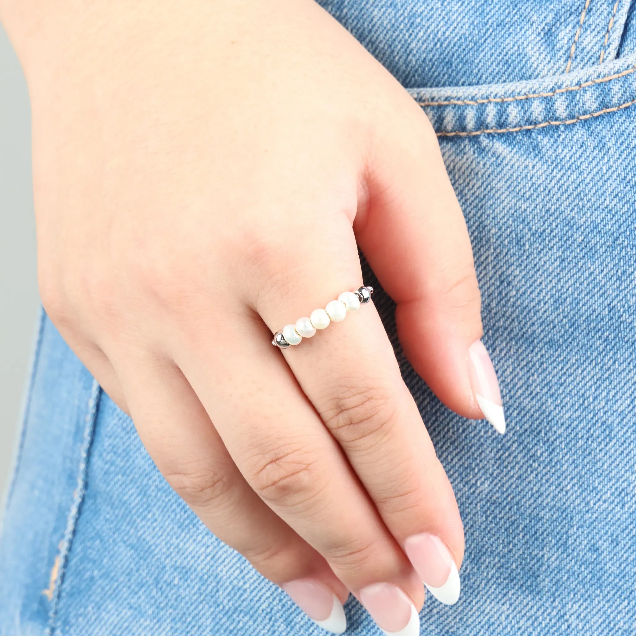 Zilveren Pearl fidget ring met parels gedragen bij spijkerbroek – Luminora