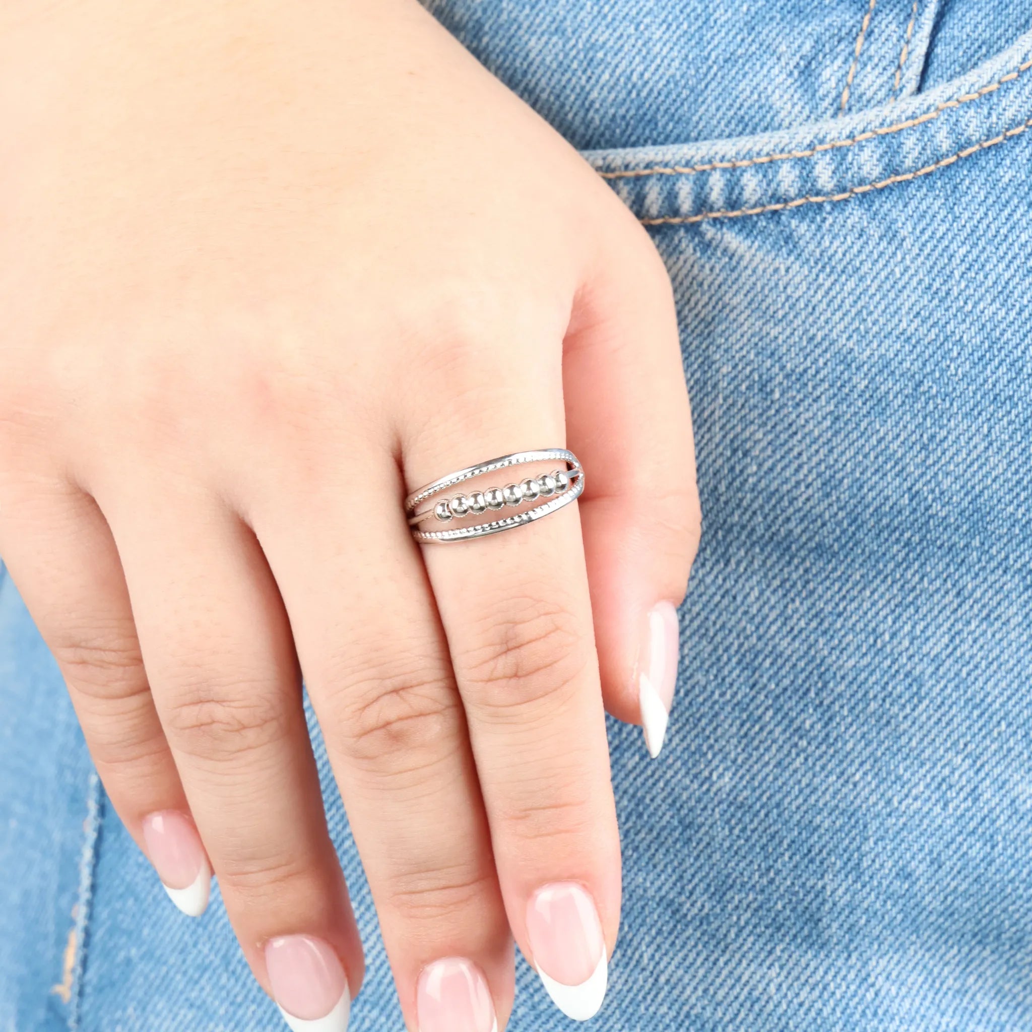 Hand draagt zilveren Pendulum fidget ring – verstelbare anxiety ring voor rust en focus