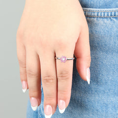 Close-up van de Petal stress ring met roze kristallen bloemblaadjes gedragen op een jeans.