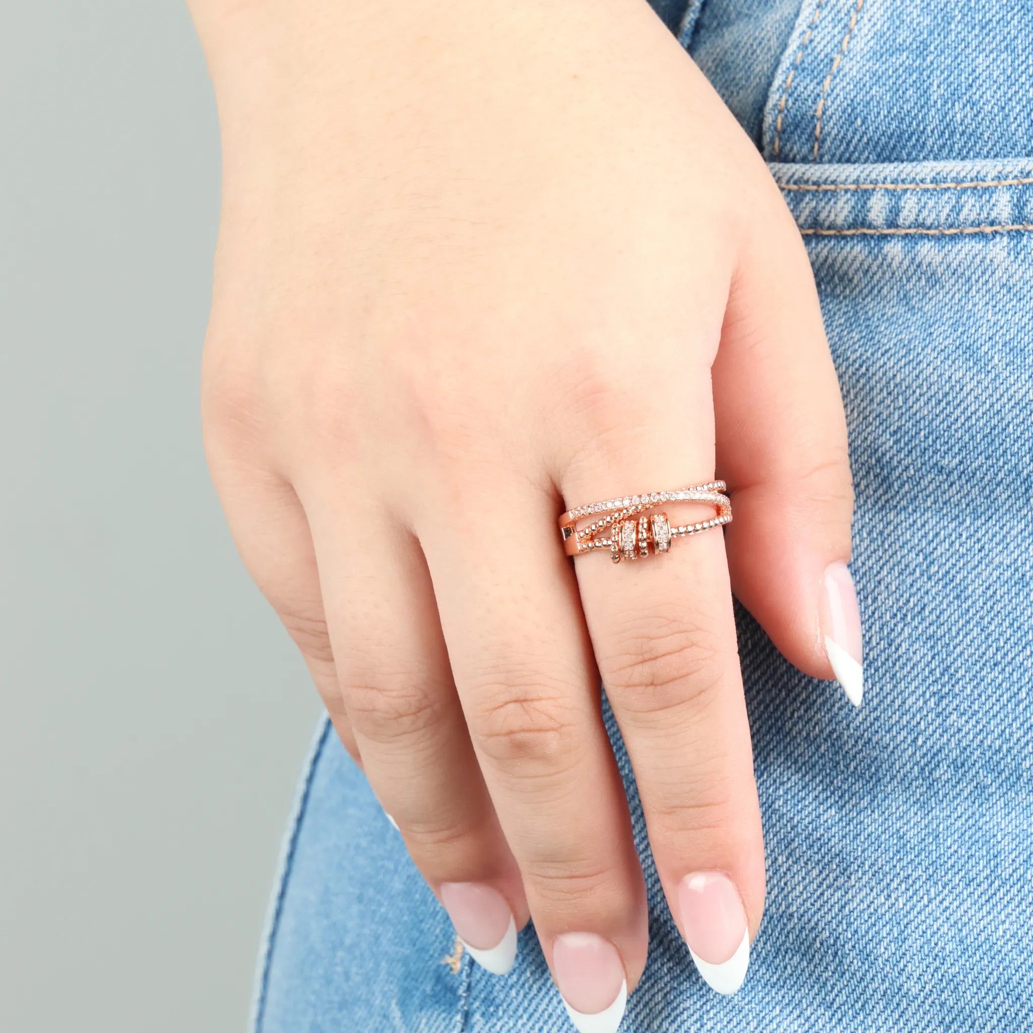 Roségouden Serenity fidget ring op blauwe jeans – elegante stress ring voor ontspanning – Luminora