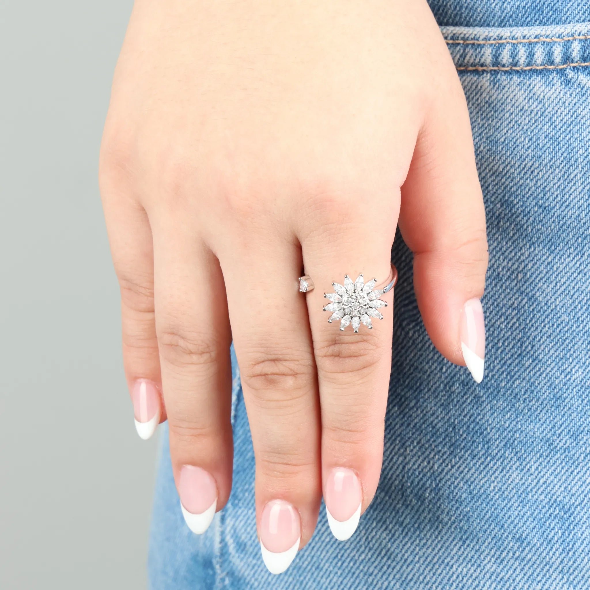 Sunflower anxiety ring in zilver gedragen op hand met spijkerbroek