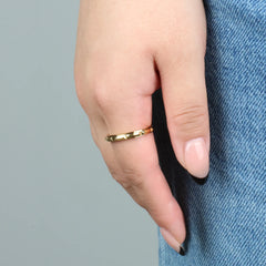 Vrouw draagt gouden Hexa fidget ring met zeshoek-detail op spijkerbroek – Luminora