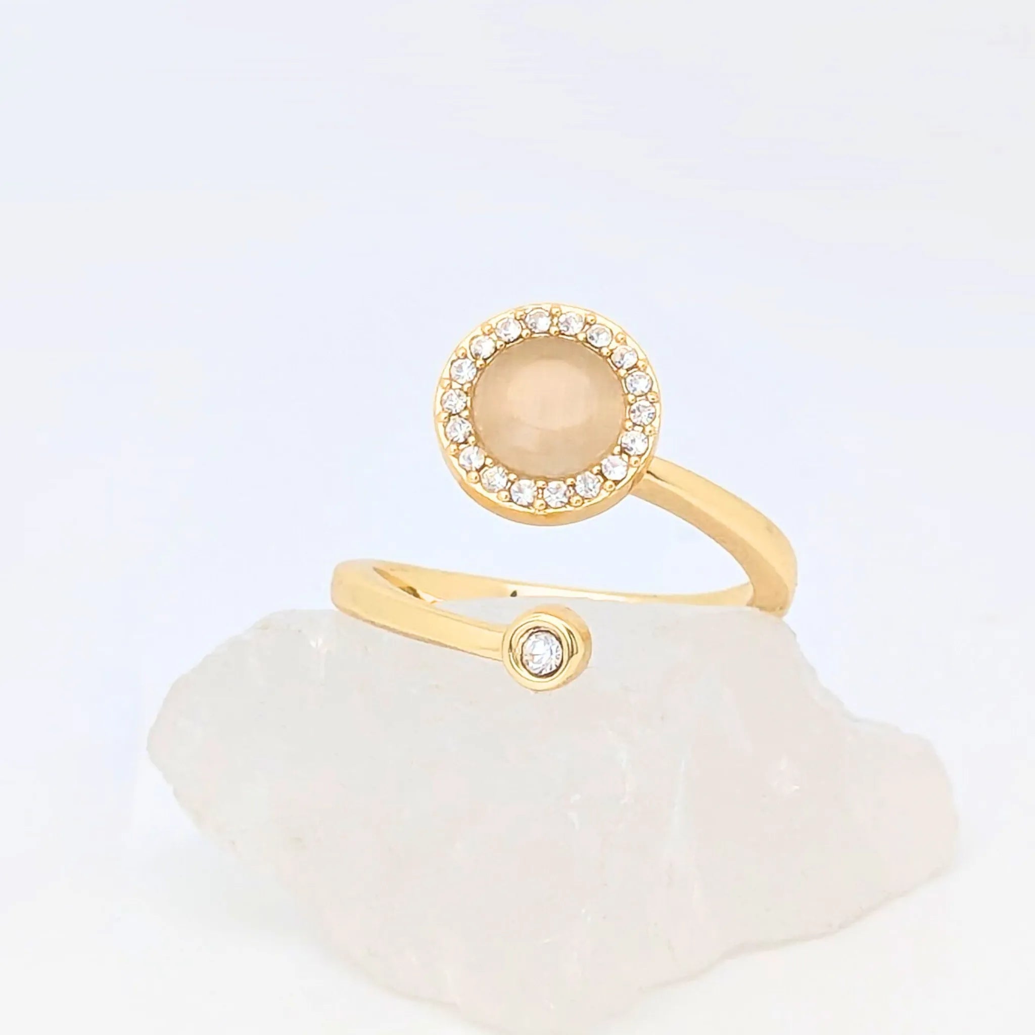 Close-up van gouden Opal wellness ring met opaalsteen en kristalrand – verstelbare ring die balans en sereniteit uitstraalt