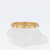 Close-up van gouden Raya wellness ring van stainless steel met kristallen in vierkante zettingen – symbool van balans en kalmte