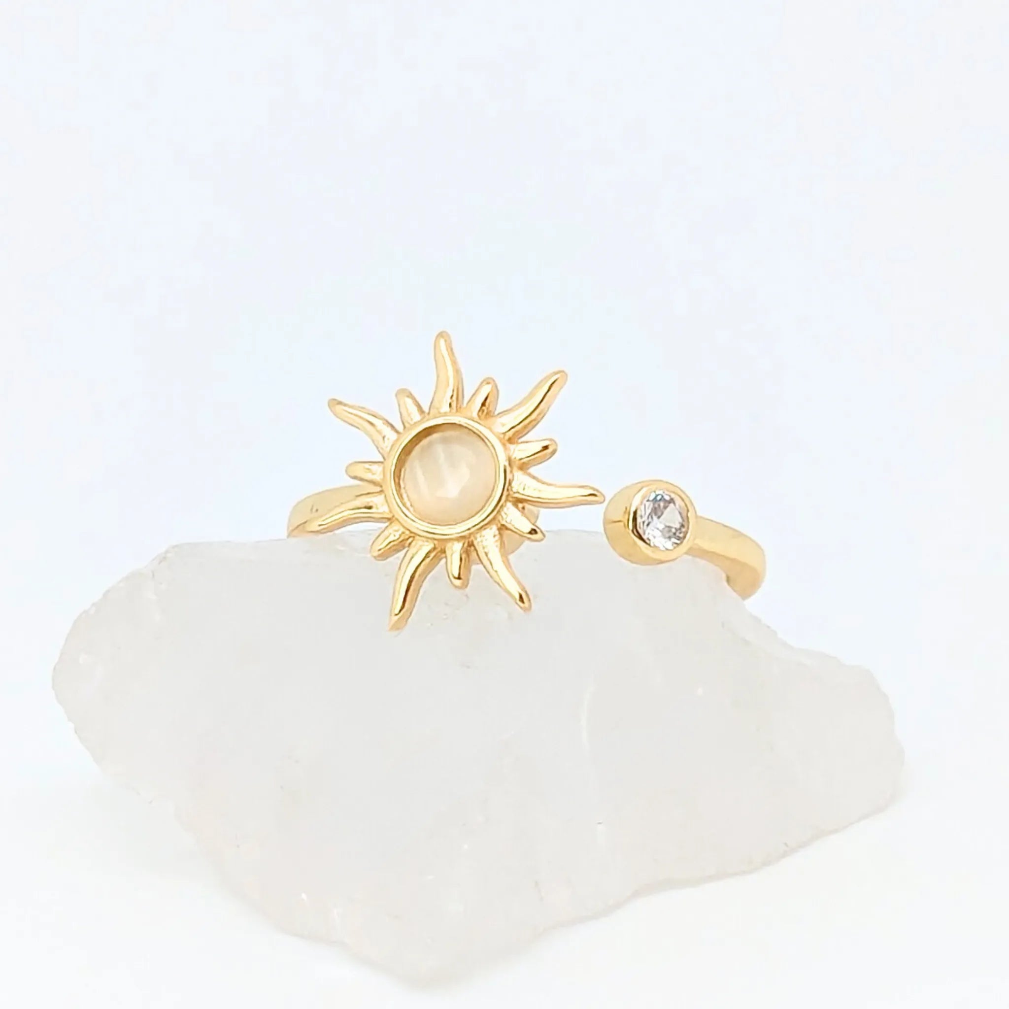 Close-up van gouden Solar wellness ring met zonvorm en ronde steen – verstelbare ring die energie en zelfvertrouwen symboliseert