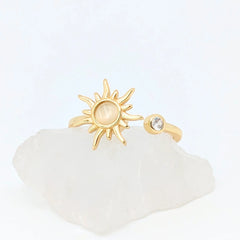 Close-up van gouden Solar wellness ring met zonvorm en ronde steen – verstelbare ring die energie en zelfvertrouwen symboliseert