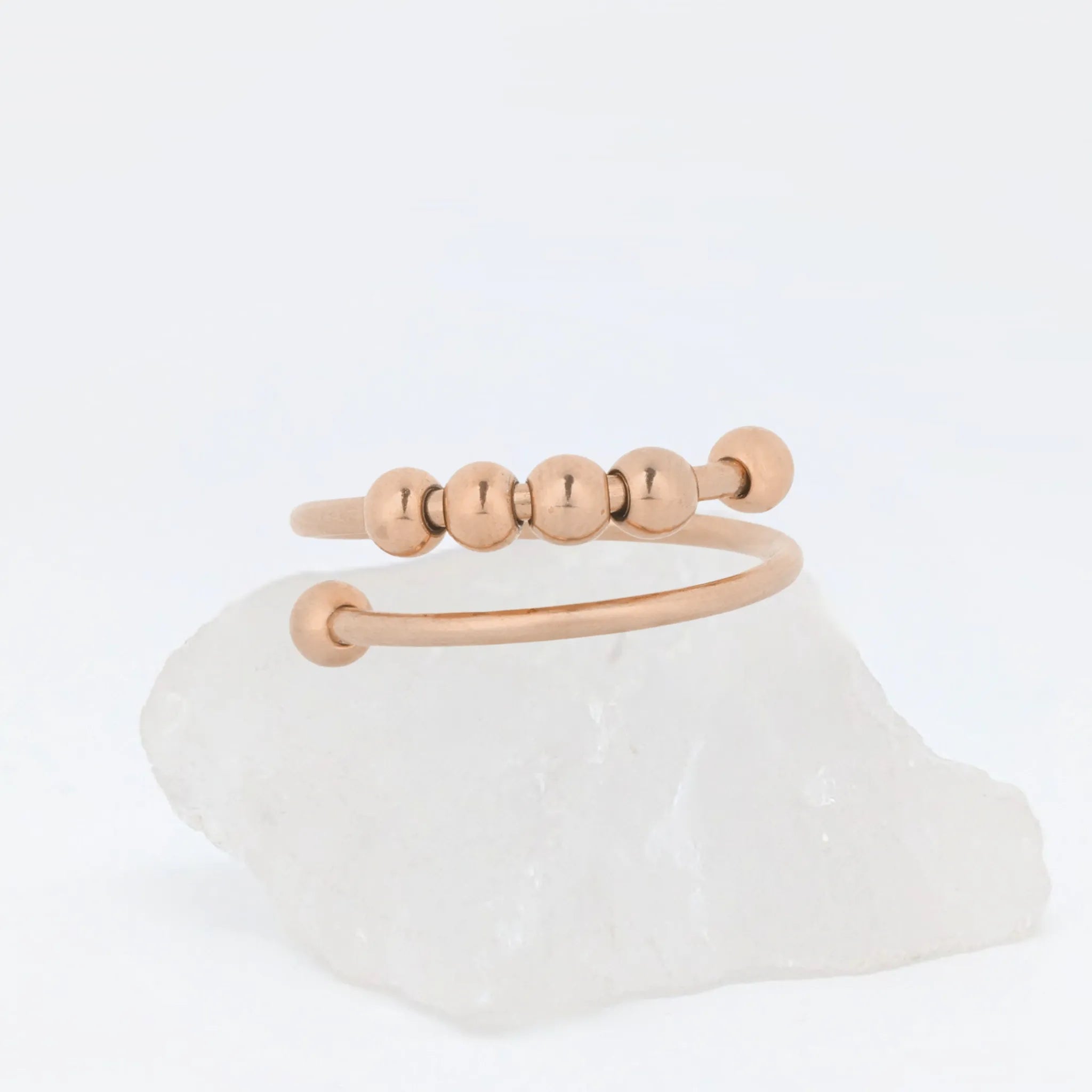 Close-up van roségouden Wave Bead wellness ring met minimalistisch design – verstelbare ring van stainless steel voor ontspanning