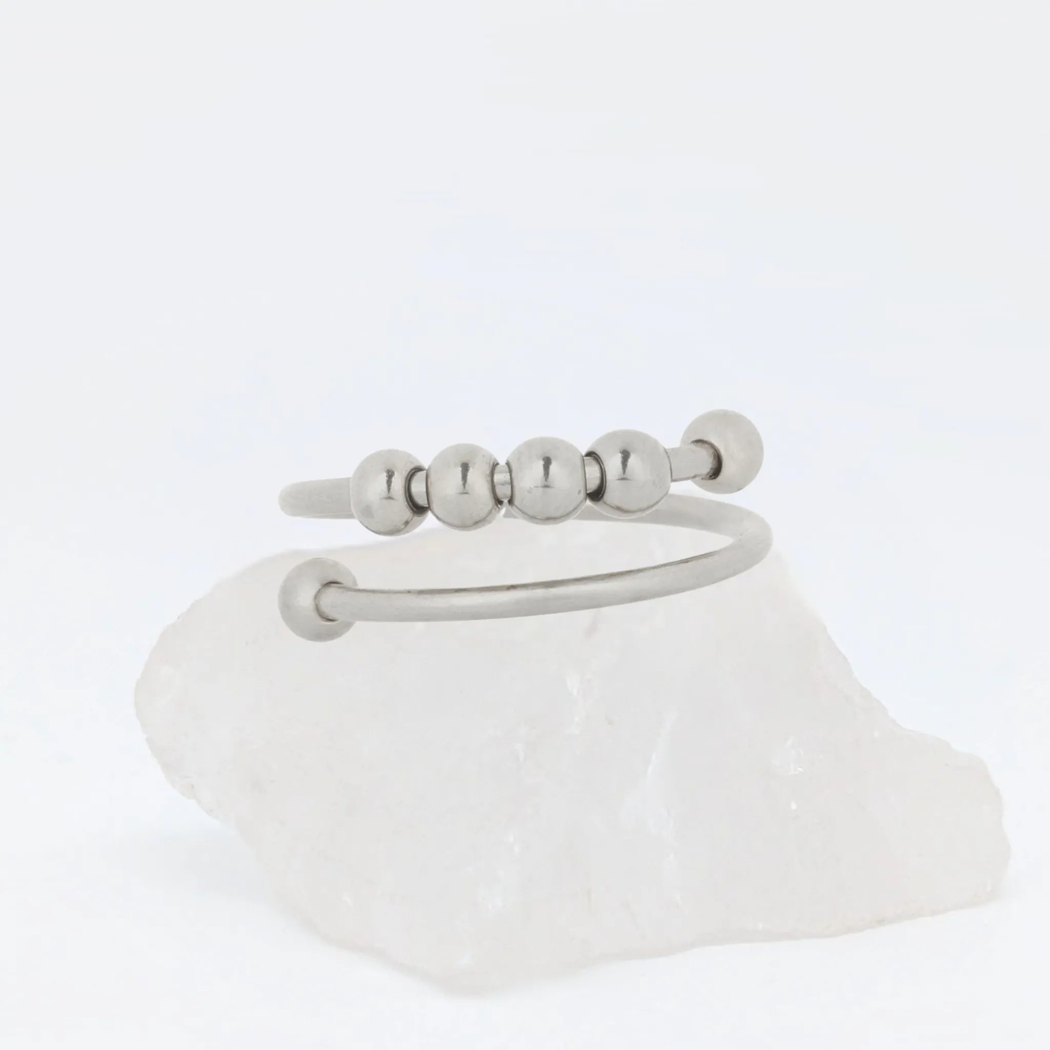 Close-up van zilverkleurige Wave Bead wellness ring met vier glanzende kralen – verstelbaar design van stainless steel voor focus