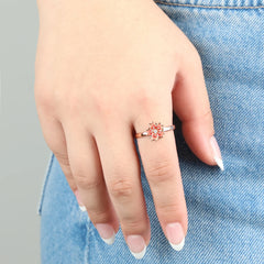 Roségouden Sakura anxiety ring met bloemvorm en heldere steen, gedragen op jeans – subtiele ring die helpt rust te vinden in stressvolle momenten
